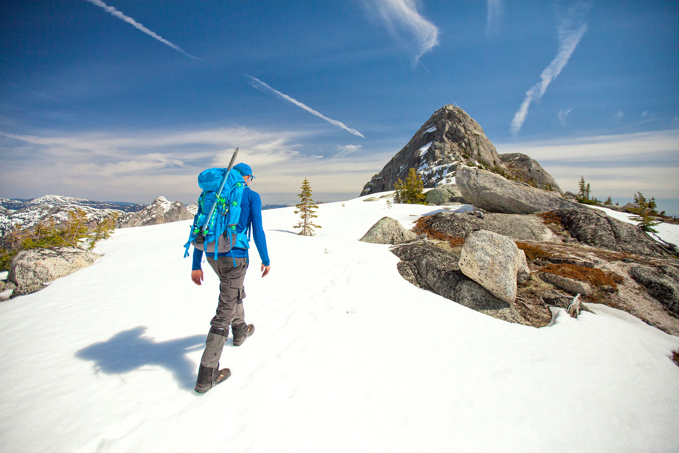 Wanderer wandert auf einem Berg der mit Schnee bedeckt ist