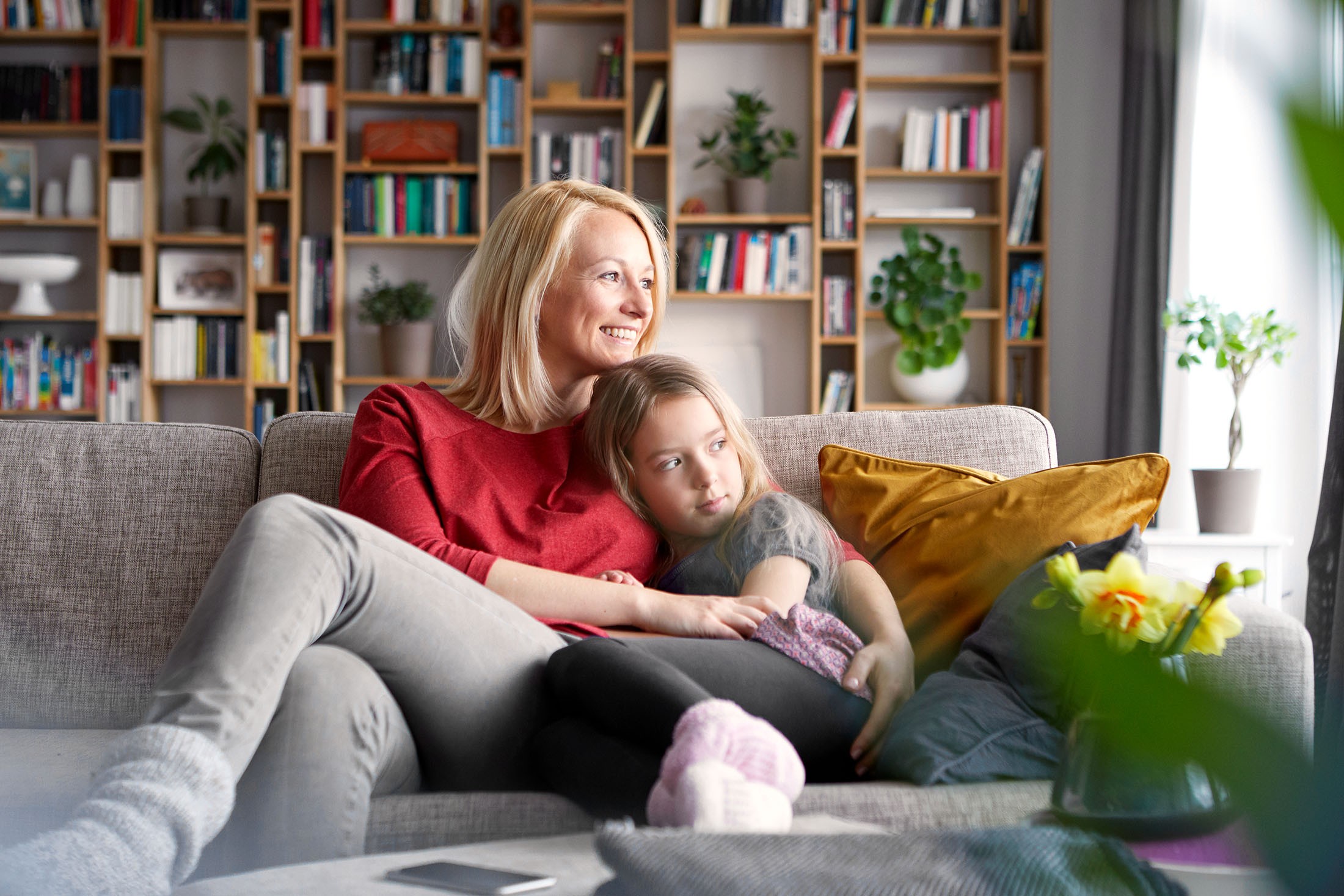 Mutter und Tochter kuscheln auf der Couch