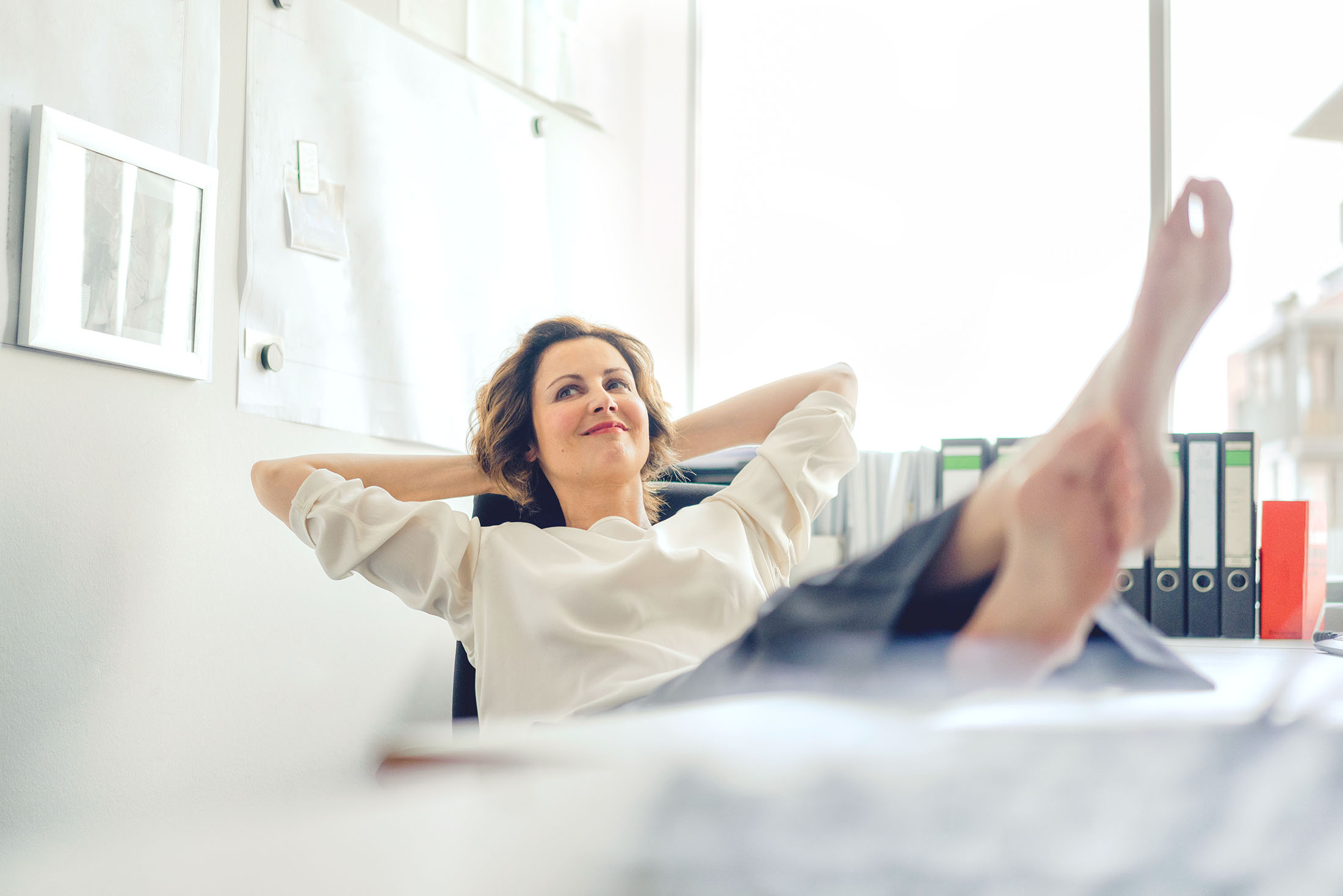 Geschäftsfrau ruht sich mit ihren Füßen auf dem Tisch im Büro aus