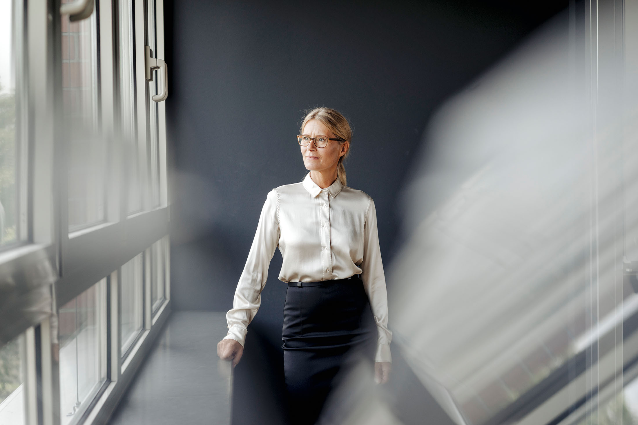 Geschäftsfrau im Büro schaut aus dem Fenster