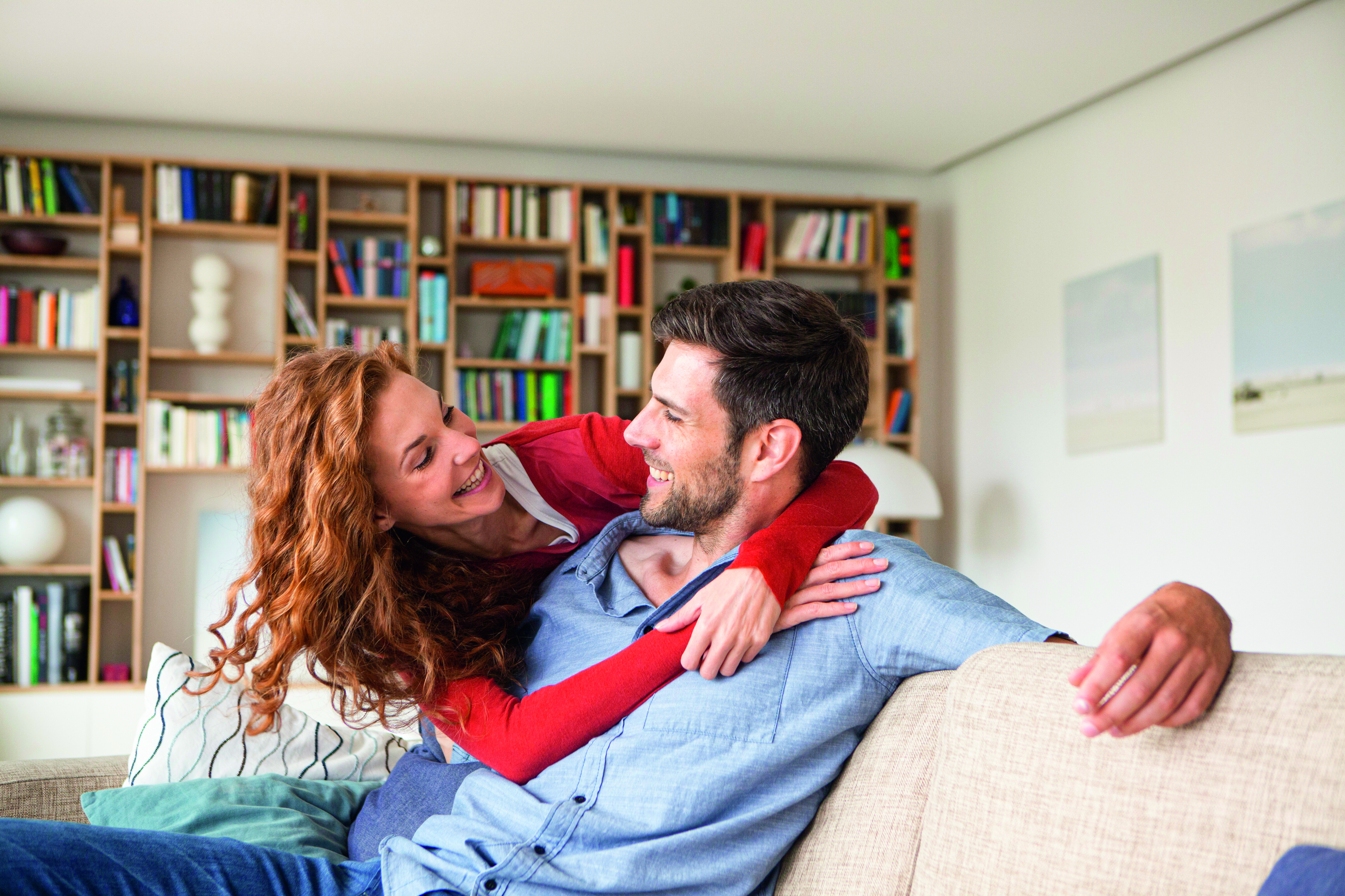 Paar sitzt zufrieden auf Sofa