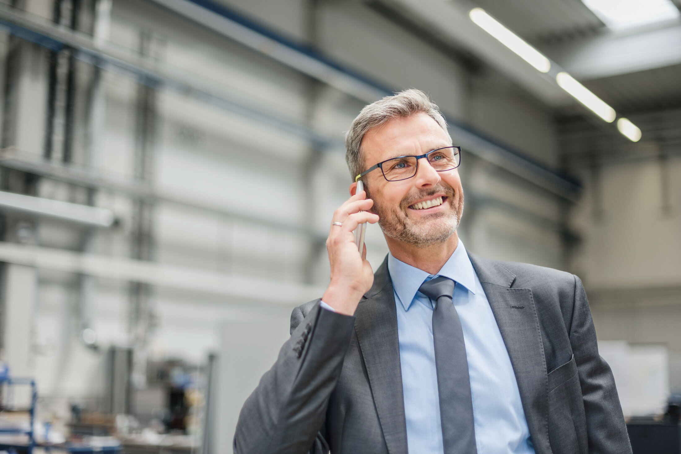 Geschäftsmann telefoniert in einer Werkshalle