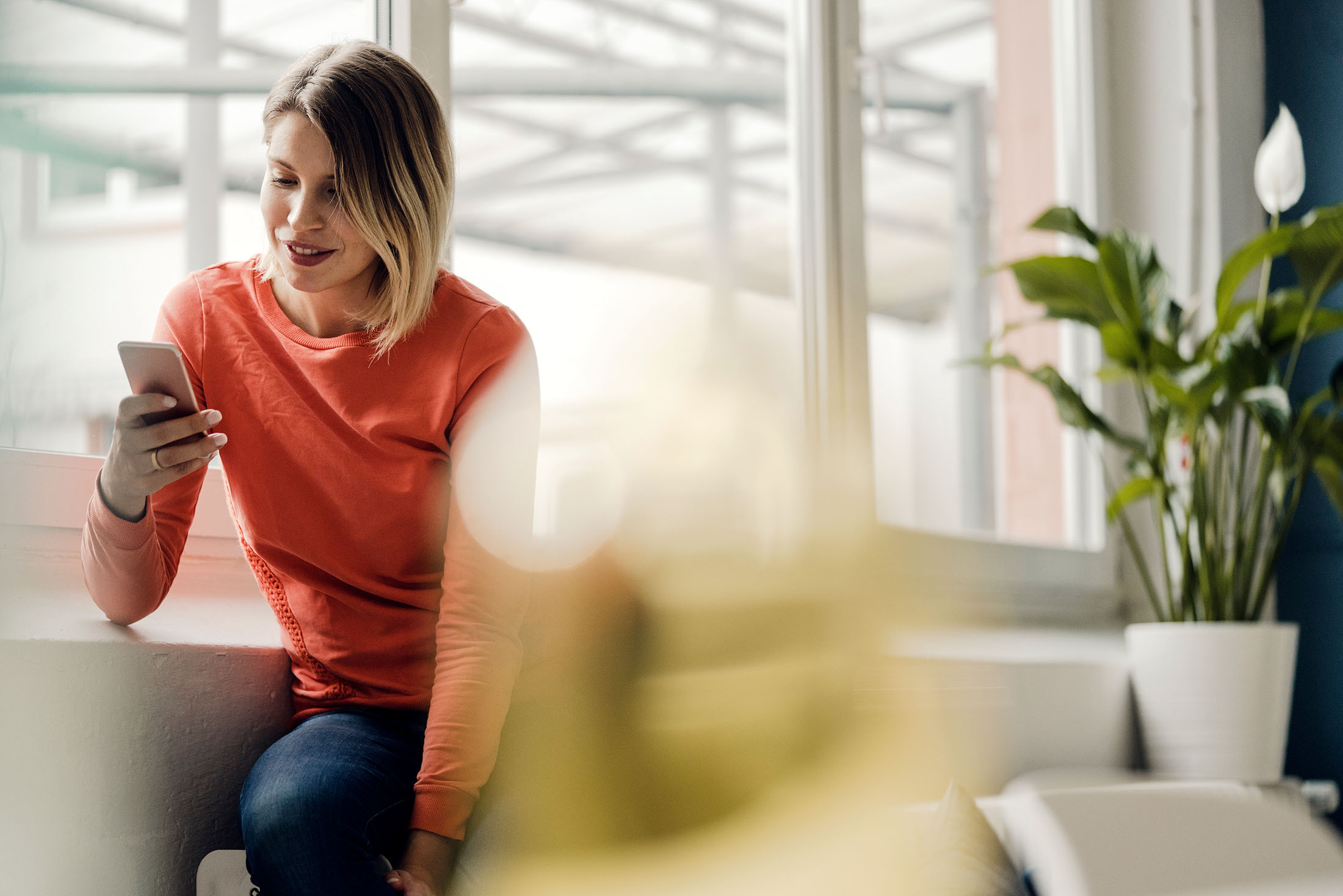 Frau benutzt ihr Mobiltelefon Zuhause